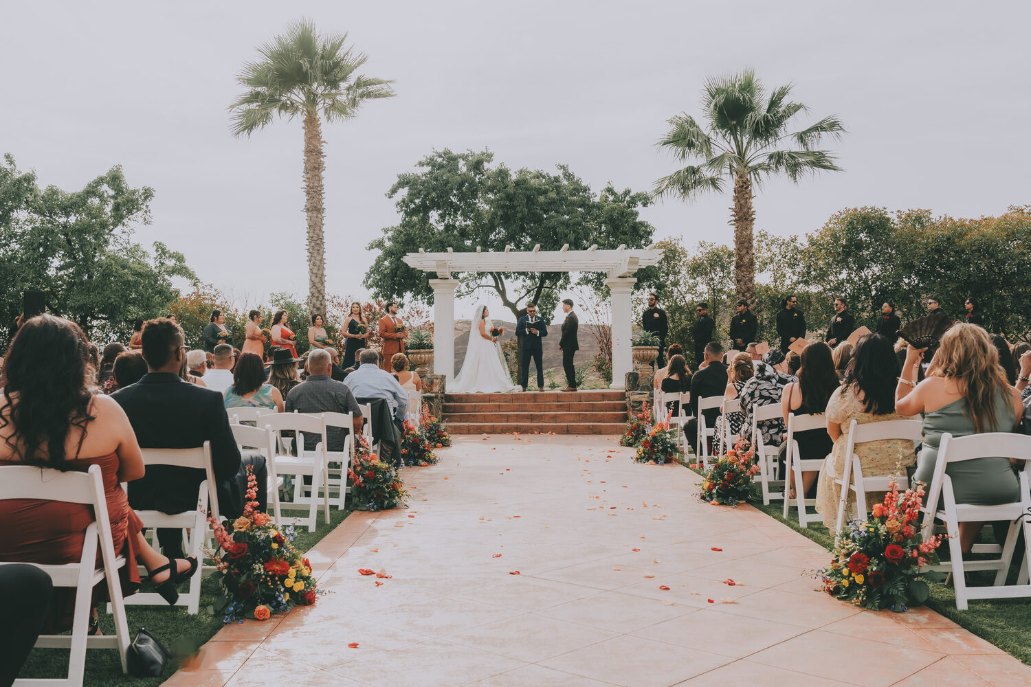 A wedding ceremony aisle framed by palms