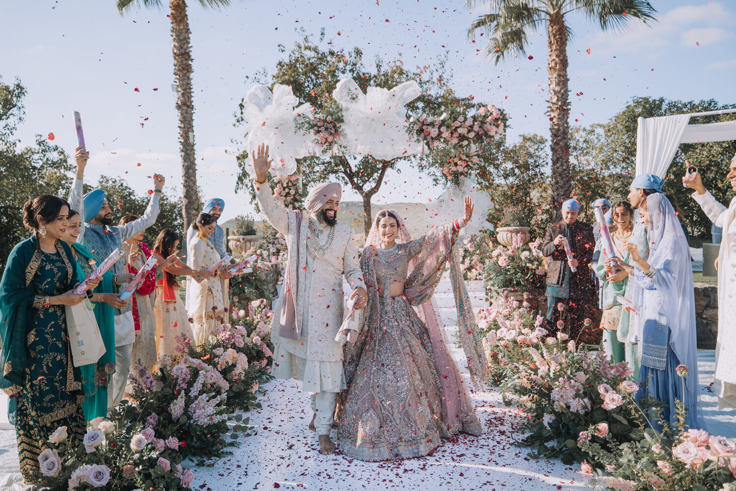 A couple showered in petals as they leave the ceremony