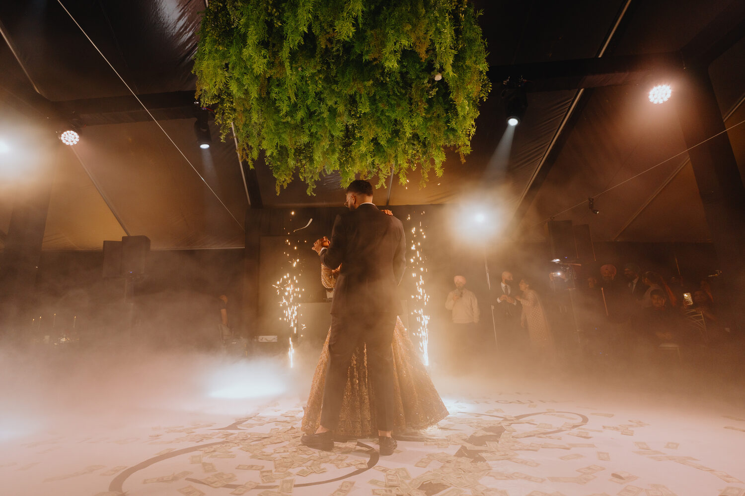 A couple's first dance wreathed in light and haze