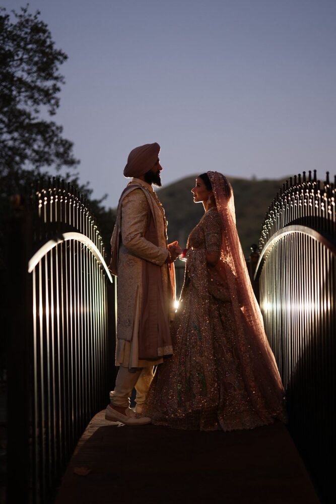 A couple at the estate's iron gates at dusk