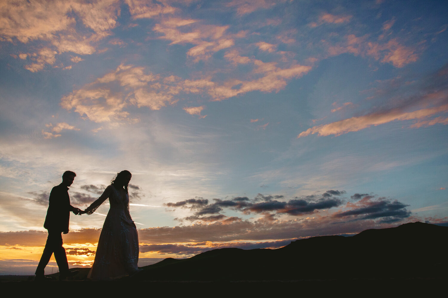 A couple silhouetted against a foothill sunset at The Clovis Castle