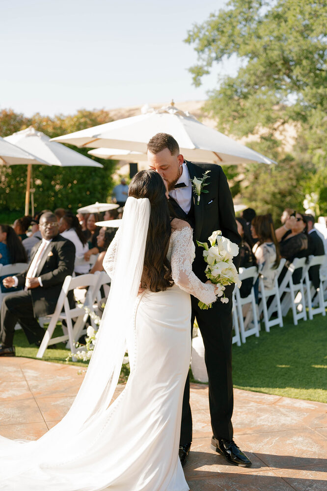 A couple's kiss beneath the garden umbrellas