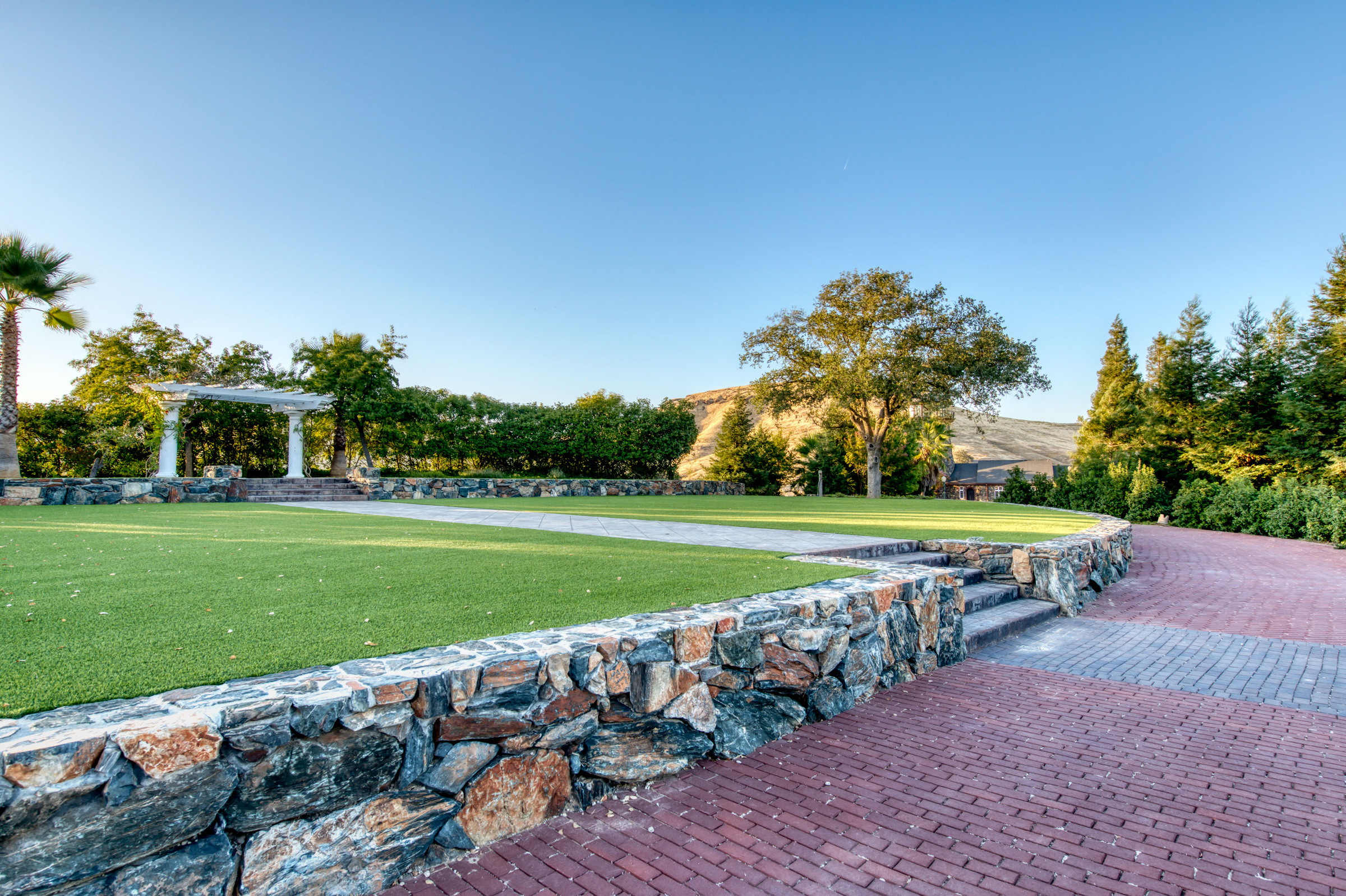 The Garden Pavilion — a white columned pergola on the manicured lawn above the foothills